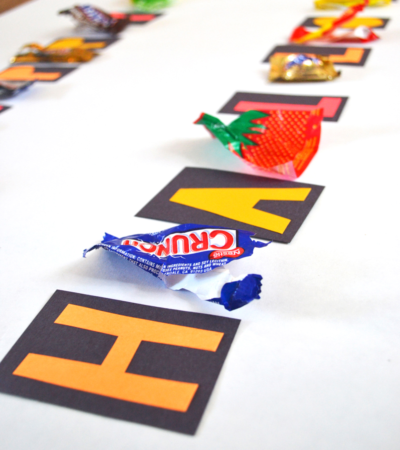 Candy wrappers and Happy Halloween letters laid out to make a garland