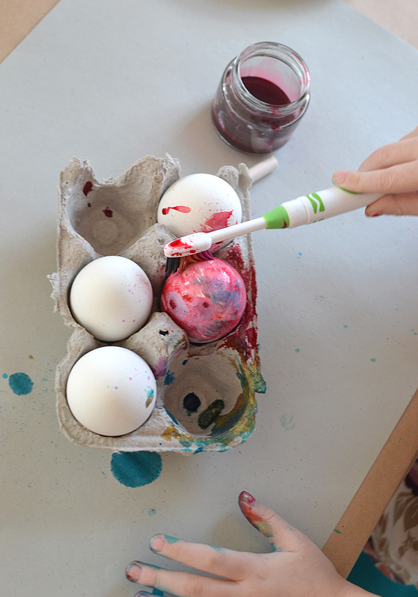 kids paint Easter eggs with a toothbrush