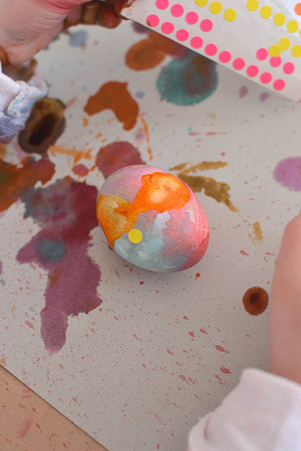 kids paint Easter eggs with a toothbrush