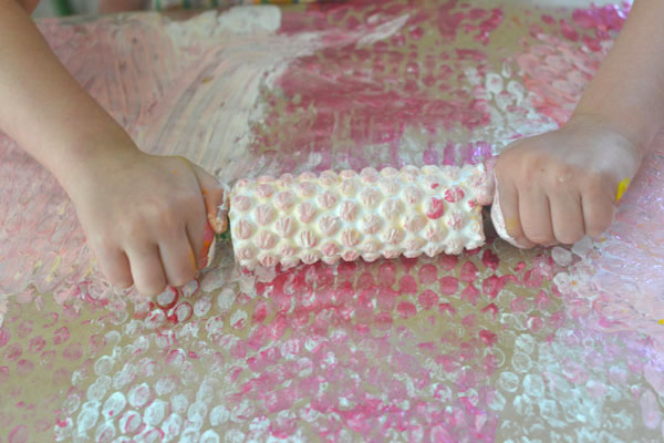 kids use their whole body when printing with bubble wrap and rollers