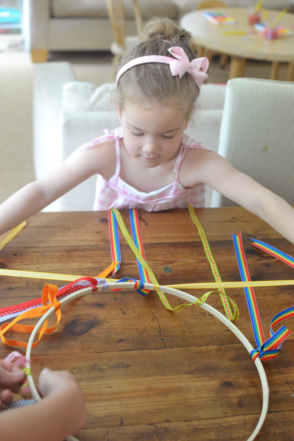 a collaborative chandelier with ribbons and pom-poms made by kids
