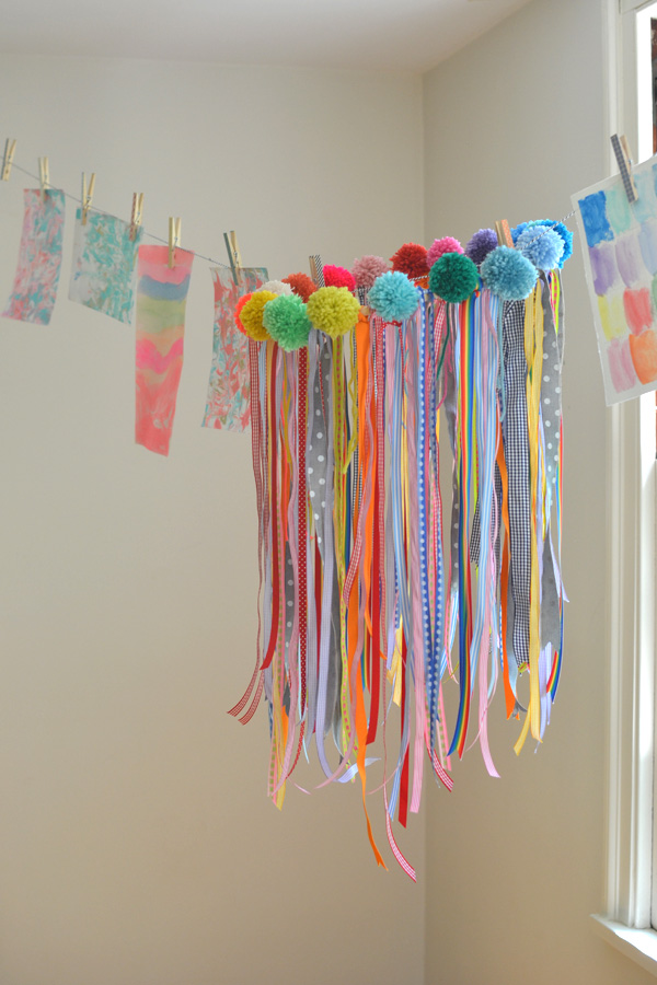 a collaborative chandelier with ribbons and pom-poms made by kids