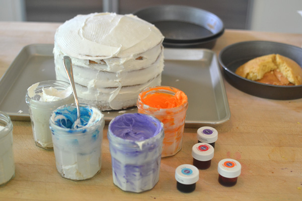 kids collaborate to make an artsy cake with colored frosting