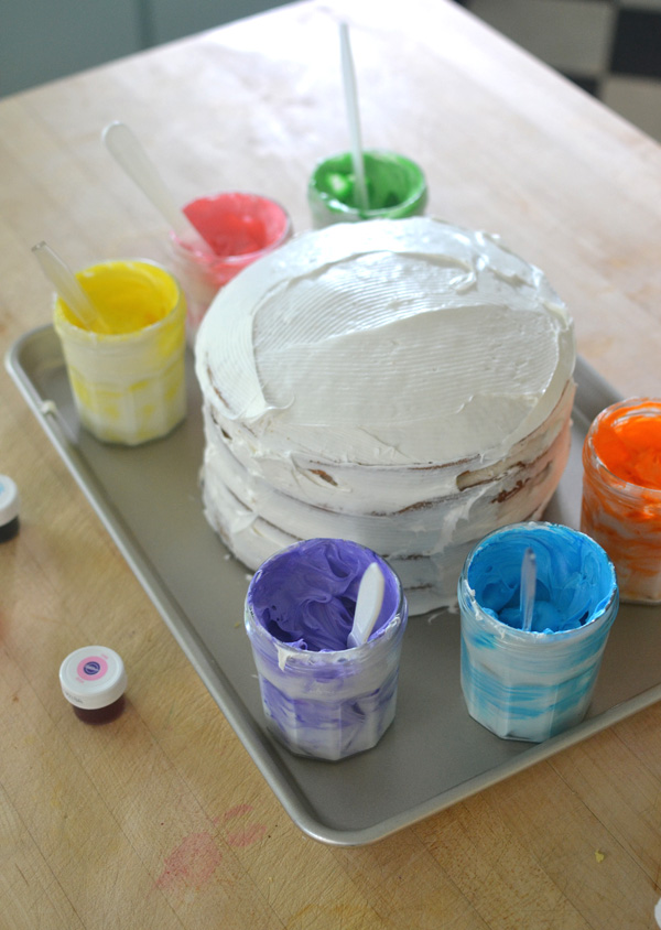 kids collaborate to make an artsy cake with colored frosting