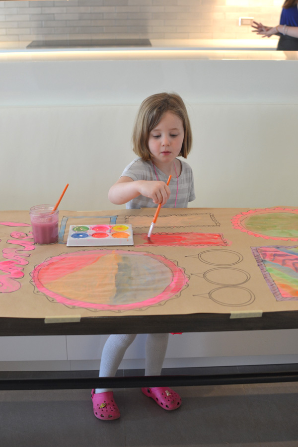 Kids collaborate to make a giant painted birthday banner