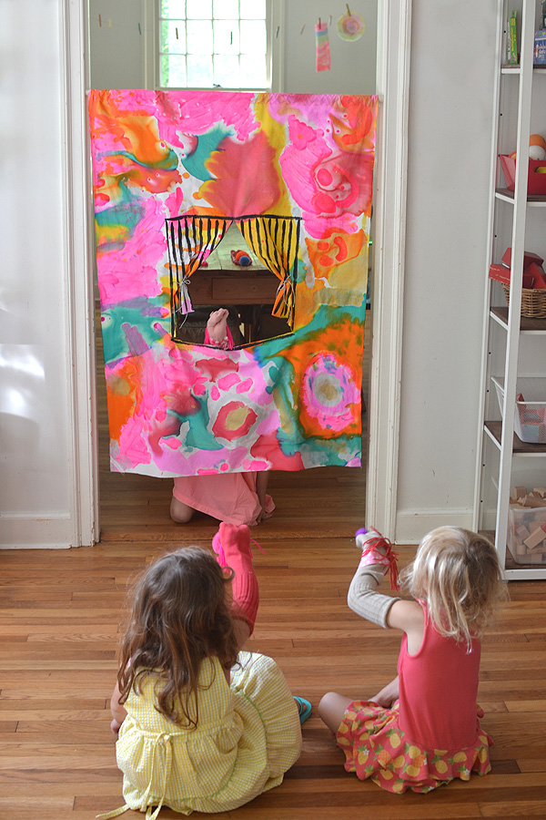 kids collaborate to paint the fabric in this homemade puppet theatre