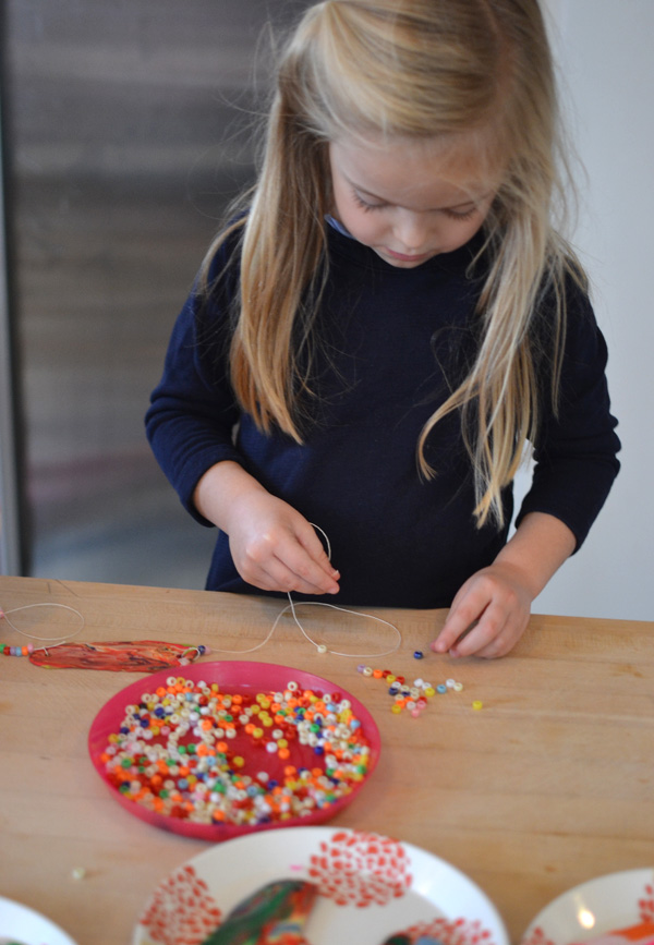 Kids use their hands to squeeze together bits of polymer clay and then use a flattening machine to make these unusual and colorful necklaces.