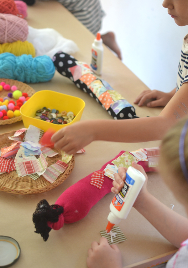 Children make these caterpillars from old socks, fabric pieces, yarn, and pom-poms.