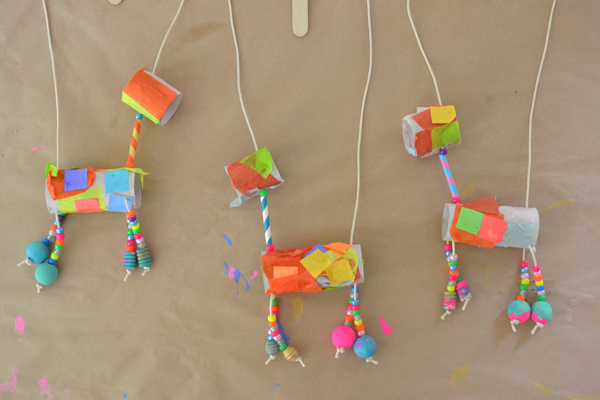 Children make marionettes from TP rolls , tissue paper, and painted beads.