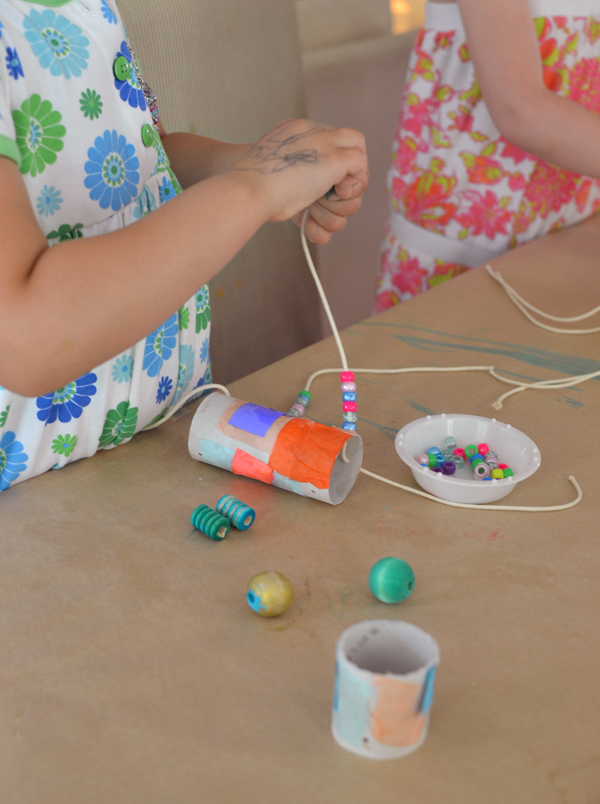 Children make marionettes from TP rolls , tissue paper, and painted beads.