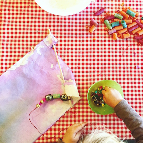 Children use liquid watercolors and spray bottles to design colorful fabric banners. 