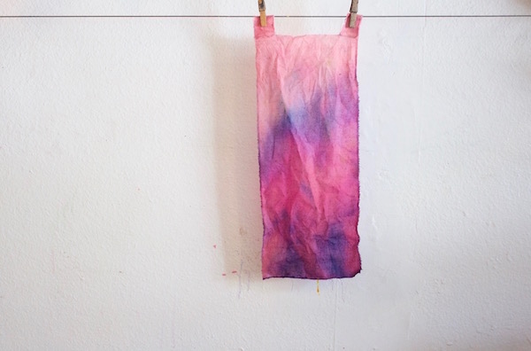 Children use liquid watercolors and spray bottles to design colorful fabric banners. 