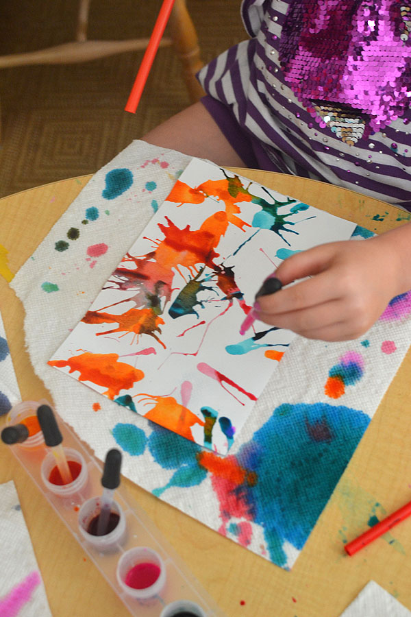Kids use liquid watercolors and straws to move the paint around on the paper and make colorful art.