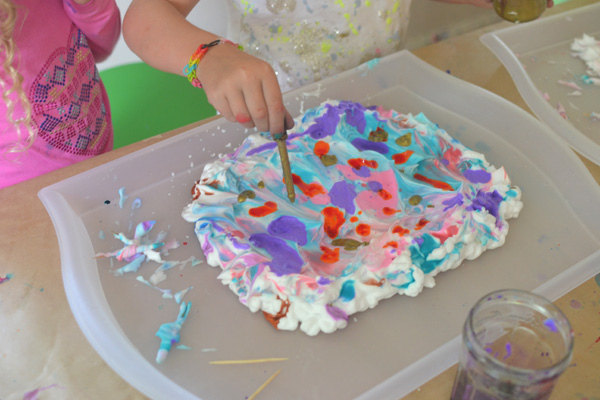 Children marble paper with shaving cream and liquid watercolors.