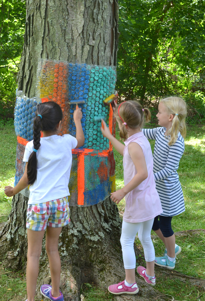 Kids use rollers and tempera paint to make print from the bubble wrap tree.