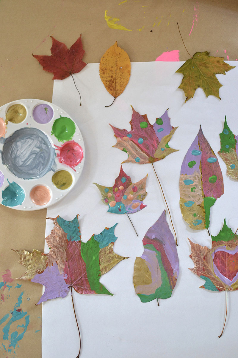 Children paint dried leaves and wrap twigs with yarn to make beautiful mobiles.