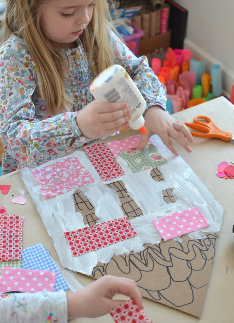Children make patchwork houses from cardboard and fabric scraps.