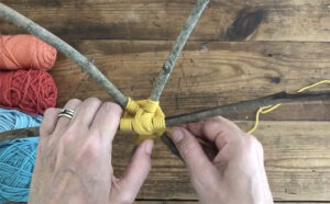 Make a six-pointed God's eye with twigs and yarn.