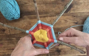 Make a six-pointed God's eye with twigs and yarn.