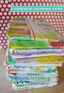 Children make homemade wrapping paper with a roll of white paper and some paint