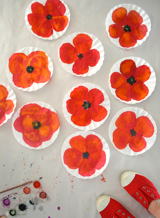 Children paint poppies using coffee filters and liquid watercolors.