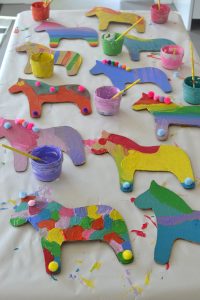 Kids paint cardboard dala horses at a birthday party. Template included.