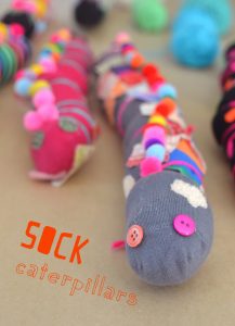 Kids make caterpillers from old socks, pom-poms, and yarn.