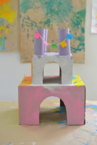 children make castles from recycled materials
