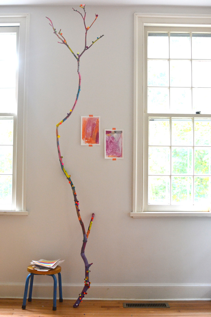 Children collaborate to paint and decorate a large branch. A wonderful process art experience.