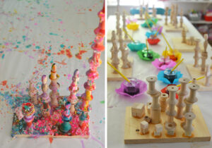using liquid watercolor to paint wooden towers and then using yarn bits for a mixed-media sculpture