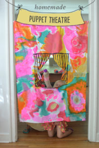 kids collaborate to paint the fabric in this homemade puppet theatre