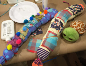 Kids and families make sock caterpillars at a community library event.