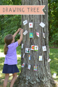Open-ended drawing prompts lead children to string a tree with drawings.