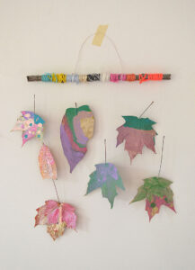 Kids paint Autumn leaves and make a mobile with yarn wrapped sticks. Gorgeous!