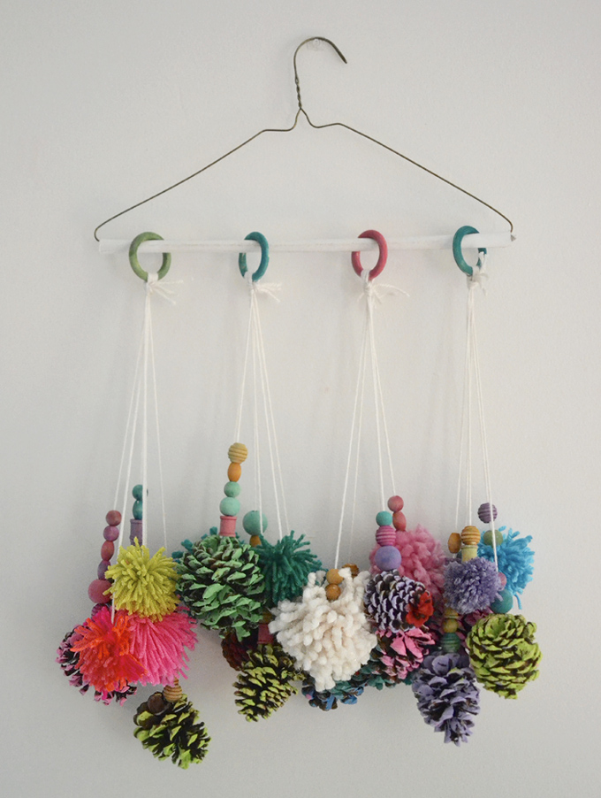 Kids make mobiles from painted pinecones and handmade pom-poms.