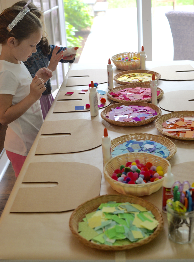 Children use colored collage material to make a rainbow from cardboard.