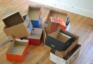 Kids collaborate to make a mansion from shoeboxes, decorating the rooms in the house with handmade furniture from recycled materials.