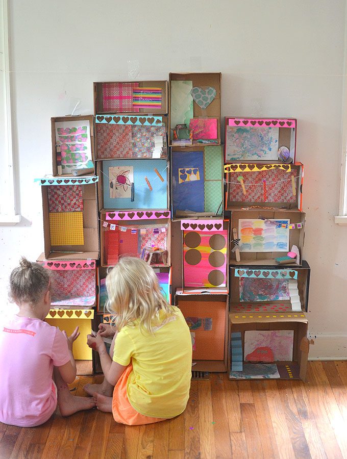 Kids collaborate to make a mansion from shoeboxes, decorating the rooms in the house with handmade furniture from recycled materials.