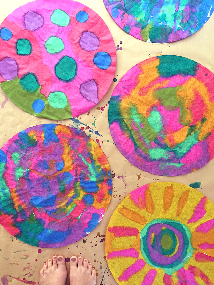 Children paint giant coffee filters hanging on a line. A wonderful process art experience.