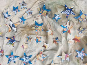 Cereal box cardboard gets cut into stars to make a glittery star mobile.