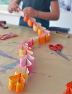 Fold paper into hearts and make a paper chain. Perfect craft for teens and tweens.