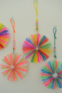 Mini paper pinwheels are set out on a table with paint as a creative invitation.