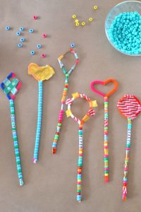 Kids make magic wands from pipe cleaners and beads.