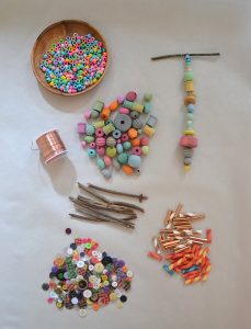 Supplies for wooden bead mobiles using wire and twigs.