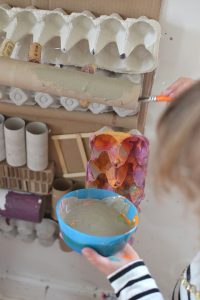 Using recycled materials, kids create a giant assemblage structure that they paint with colors they mixed themselves. A beautiful process art experience!