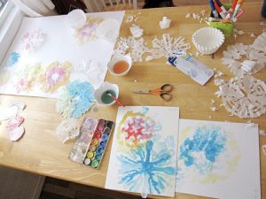 Painting coffee filter snowflakes with watercolors.