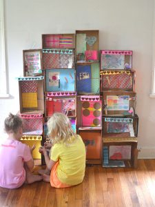 Kids make a structure from shoe boxes.