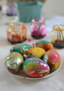 Children paint gorgeous wooden eggs for Easter.