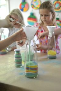 Dye sand from the beach for kids to make sand art in tall, pear juice bottles.