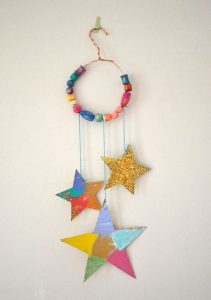 Kids make glittery star mobiles with cardboard, wire, and painted wooden beads.